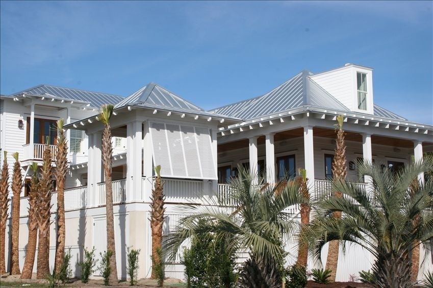 Rosemary Beach style white coastal home with covered balconies and palm trees